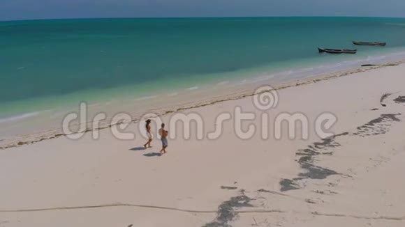 从上面看布格苏克岛上的蓬塔空中拍摄的旅行情侣漫步一望无际的白色沙滩周围是绿松石视频的预览图