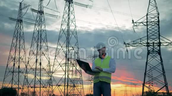 日落景观与电气线路和男性专家视频的预览图