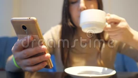 在咖啡馆里喝咖啡用手机视频的预览图