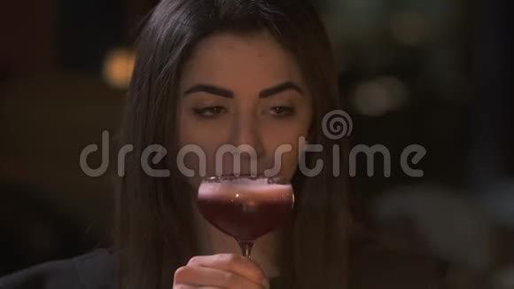 悲伤的年轻女子在咖啡馆里喝着高杯鸡尾酒的肖像孤独女士的休闲视频的预览图