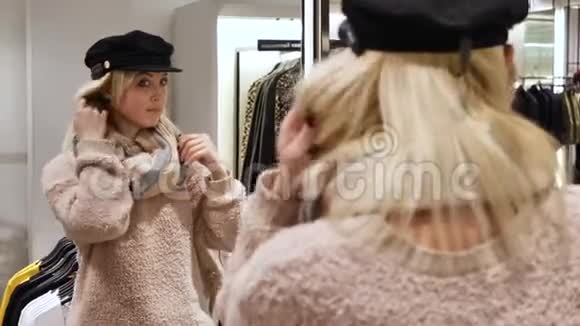 一个女人戴着镜子旁边的面罩试戴帽子视频的预览图