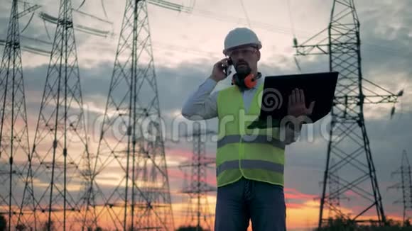 输电线路和一名男性工人打电话视频的预览图