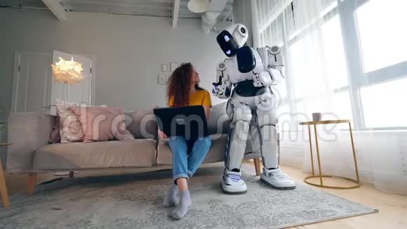 Cyborg和人类概念年轻女性和半机械人用笔记本电脑工作视频的预览图