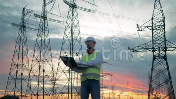 电力线路建设和一名男性工程师操作笔记本电脑视频的预览图