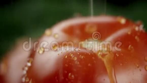 在视频中我们看到了一个西红柿和绿色植物水从顶部像波浪一样倾泻黑色的背景特写视频的预览图
