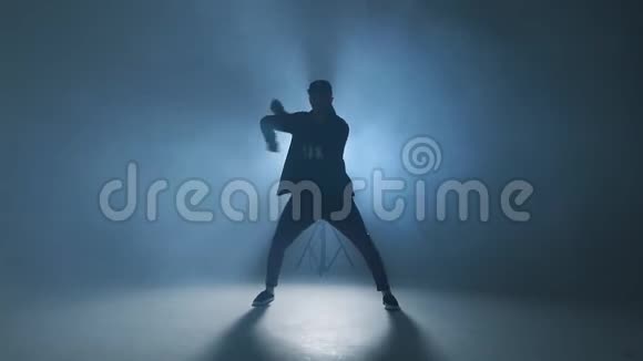 运动现代风格的嘻哈舞者展示他的舞蹈蓝色工作室背景慢动作视频的预览图
