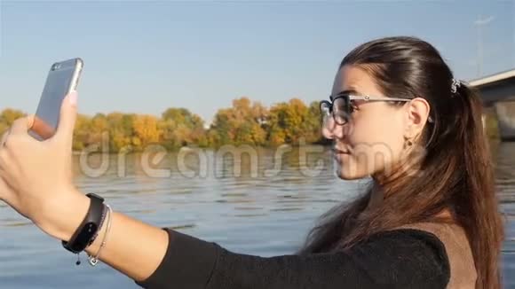 一个年轻女孩在水边自拍特写镜头慢动作视频的预览图