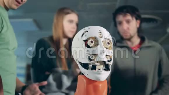 男人和女人说话检查机器人的头部闭上眼睛视频的预览图