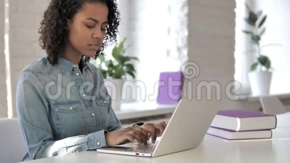 在笔记本电脑工作时脖子疼的非洲女孩视频的预览图