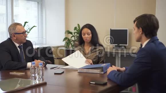 非裔美国律师向高级商人和年轻的首席执行官提交法律文件视频的预览图