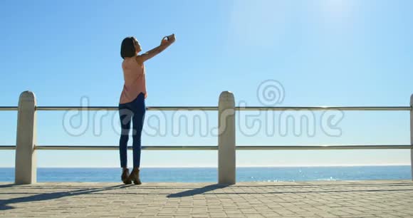 女人在海边捕捉日落的天空视频的预览图