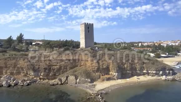 从空中俯瞰中世纪的塔在NeaFokea海滩和一艘小船在港口Halkidiki希腊向后移动博士视频的预览图