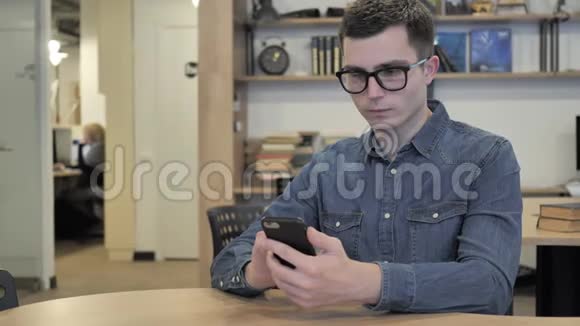 眼镜中的创意青年在使用智能手机时应对损失视频的预览图