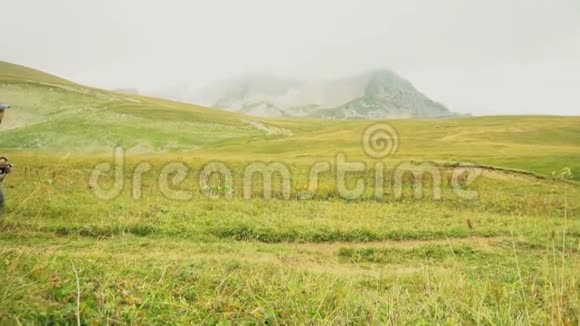 带背包的小男孩在风景优美的青山里徒步旅行慢动作120英尺视频的预览图