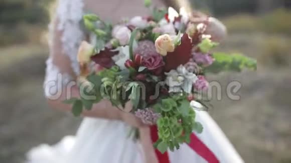 新娘捧着美丽的鲜花玫瑰花束和礼物视频的预览图