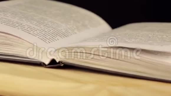 打开的书在木平台上旋转360度视频的预览图