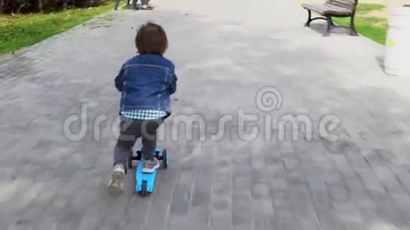 儿童骑滑板车在绿色踢脚板视频的预览图