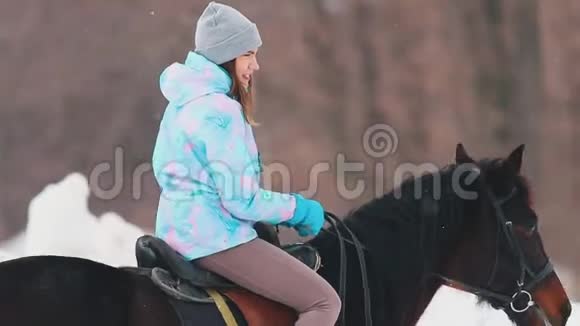 冬天的时候下雪了一个年轻的女人在一个村庄骑马视频的预览图