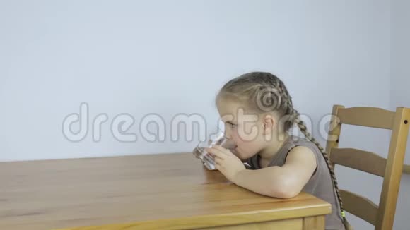 女孩坐在厨房里急切地喝水视频的预览图