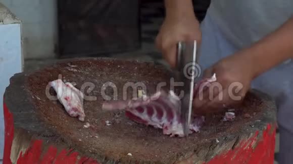 一个男人正在用一只羊的新鲜肉切割有人把骨头炸了视频的预览图