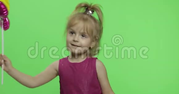 女孩以花的形式拿着气球快乐的四岁女孩色度键视频的预览图