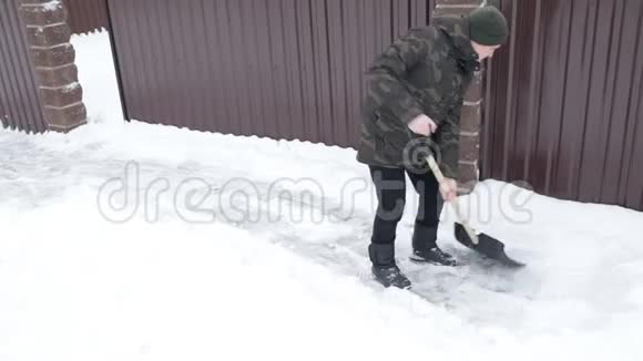 男人用一把大铲子在房子附近清理积雪视频的预览图