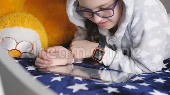 少女使用电子平板电脑躺在沙发上温暖PJ视频的预览图
