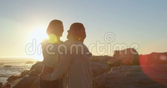 幸福的年轻夫妇在岩石海岸相互交流视频的预览图
