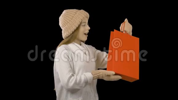 红发少女戴着粉红色的帽子和玩偶手里拿着新年礼物真诚地欣赏着黑色的微笑视频的预览图
