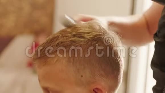 理发师用吹风机吹干头发用桨刷视频的预览图