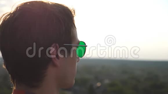 从高楼大厦的屋顶观看城市全景的年轻人戴着太阳镜帅哥看起来视频的预览图