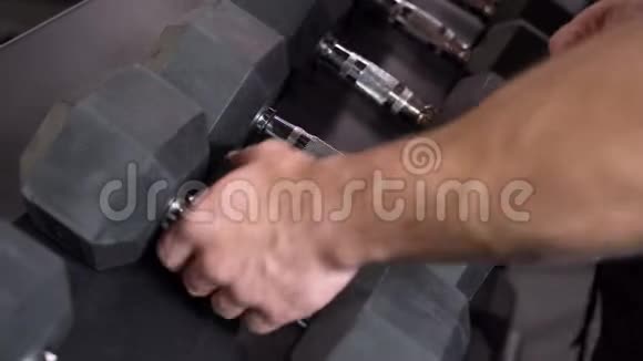 在健身房里做哑铃的男性手部特写视频的预览图