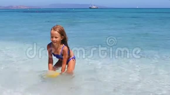 可爱的小女孩在热带海滩的浅水中玩海滩玩具视频的预览图