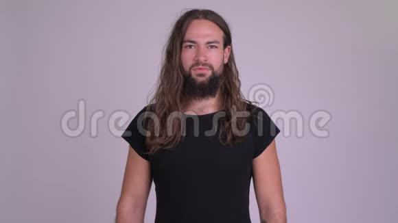 一位留着长发竖起大拇指的年轻留着胡须的时髦男人视频的预览图