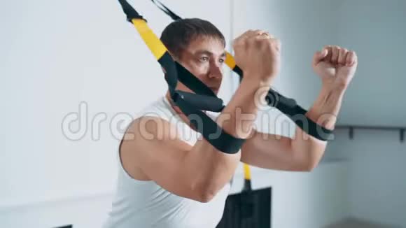 一个男人使用TRX循环参与健身房锻炼胸部肌肉视频的预览图