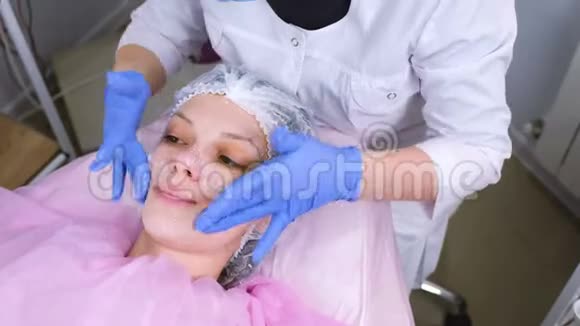 美容师把面具戴在女人脸上洗洗脸视频的预览图