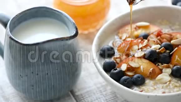 在早餐粥和水果中加入枫糖浆视频的预览图