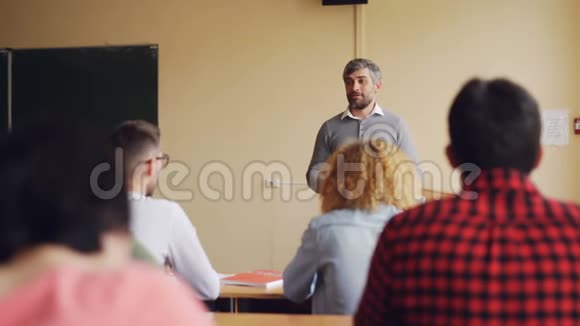 友好的老师正在和他的学生交谈检查知识年轻人正在举手回答问题其他的视频的预览图
