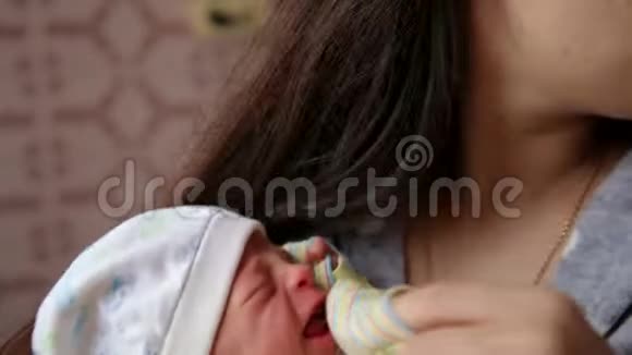 可爱的哭泣新生婴儿在妈妈手上新生儿哭泣的婴儿孩子们哭视频的预览图