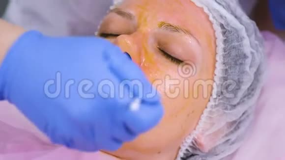 美容师用刷子把女人的脸化学剥落清洁面部皮肤减轻雀斑皮肤视频的预览图