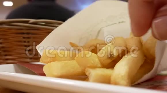 男子在食物场桌上吃薯条的动议视频的预览图