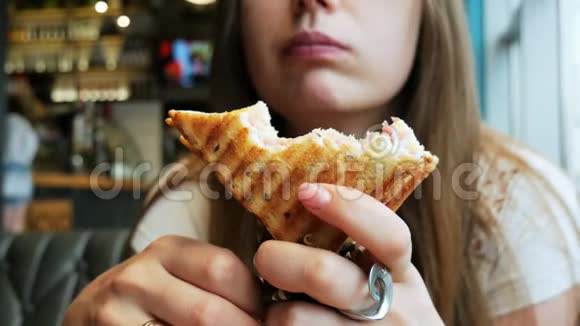 一位饥饿的年轻女士在咖啡馆快餐店吃烤面包视频的预览图