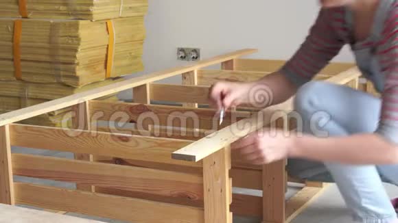 非女性工作年轻女子在室内组装木制家具视频的预览图