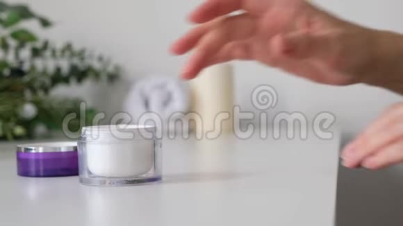 女人把奶油涂在她的手上白色的背景特写水疗化妆品视频的预览图