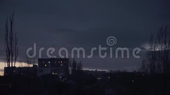 城市边缘房屋和树木后面的暮色和飞舞的云彩视频的预览图