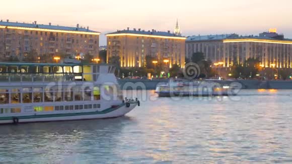 晚上河上的出租车在海峡上驶过灯火通明的建筑物视频的预览图