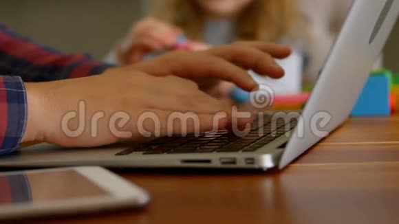 父亲用笔记本电脑女儿在客厅玩粘土视频的预览图