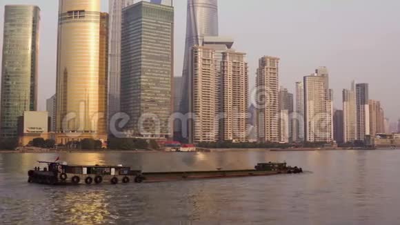 拉登用碎石在黄浦江上的驳船背景是玻璃摩天大楼的中心视频的预览图