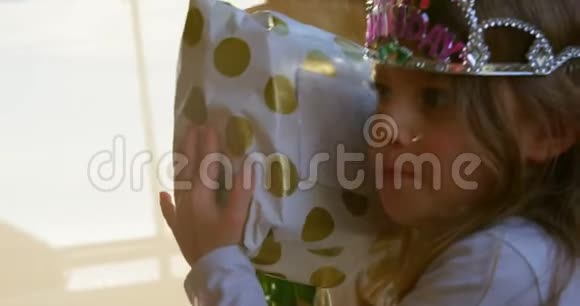 可爱的女孩在家摇生日礼物视频的预览图