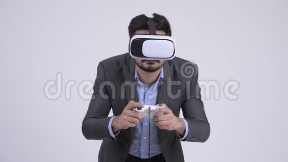 年轻留胡子的印度商人玩游戏使用虚拟现实耳机视频的预览图